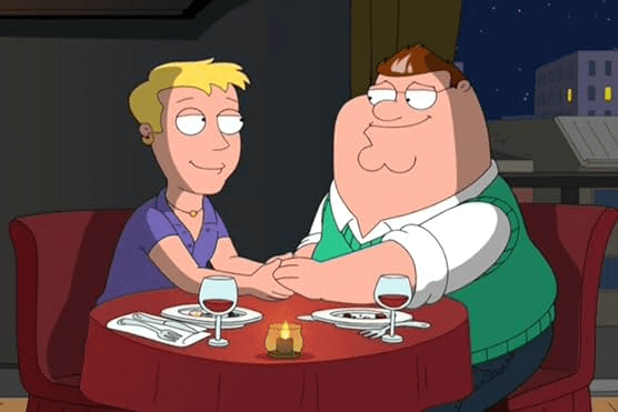 imagem_2024-05-25_183341111 Foto de um episódio da série Family Guy. Dois personagens homens estão sentados numa mesa, segurando a mão um do outro.