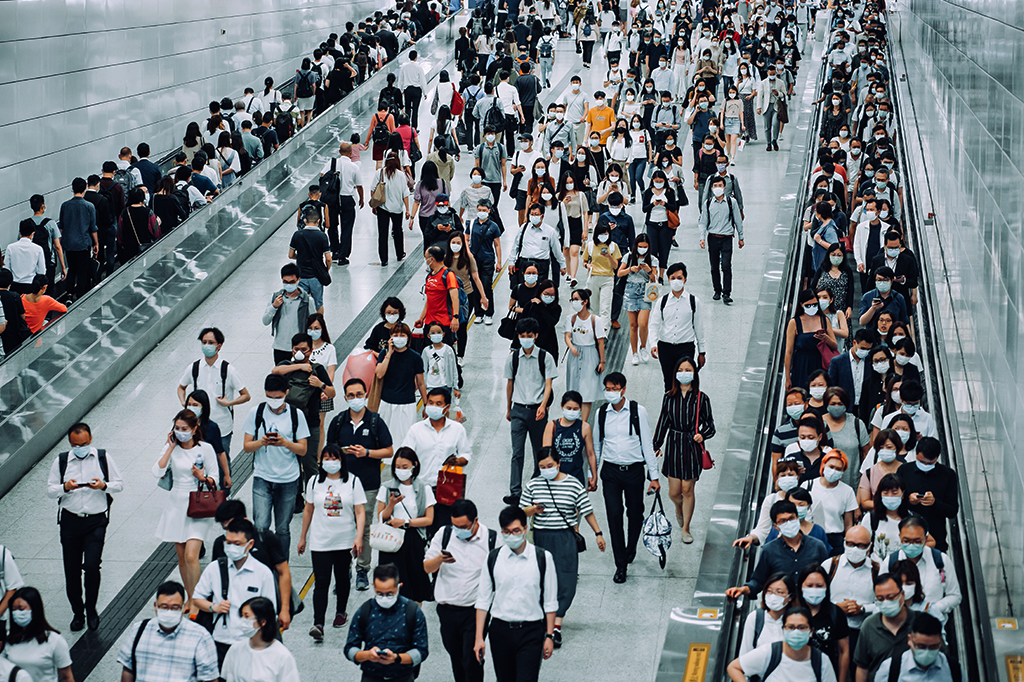 Pessoas transitando pelas plataformas do metro, na China, usando máscaras.