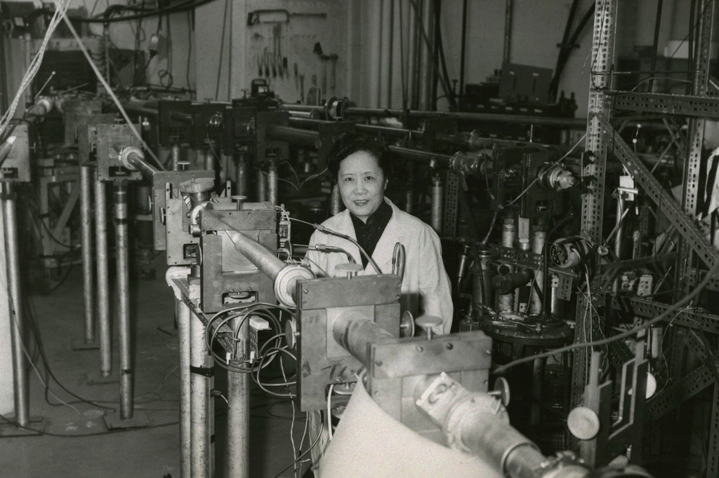 Foto em preto e branco de Chien-Shiung Wu vestindo um jaleco branco.