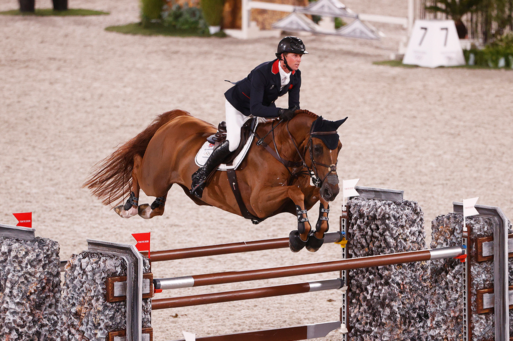O cavaleiro Ben Maher, medalhista de ouro da Grã-Bretanha, com seu cavalo, saltando obstáculos durante a competição em Tóquio.