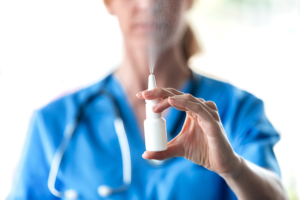 Pessoa da área da saúde segurando um spray nasal