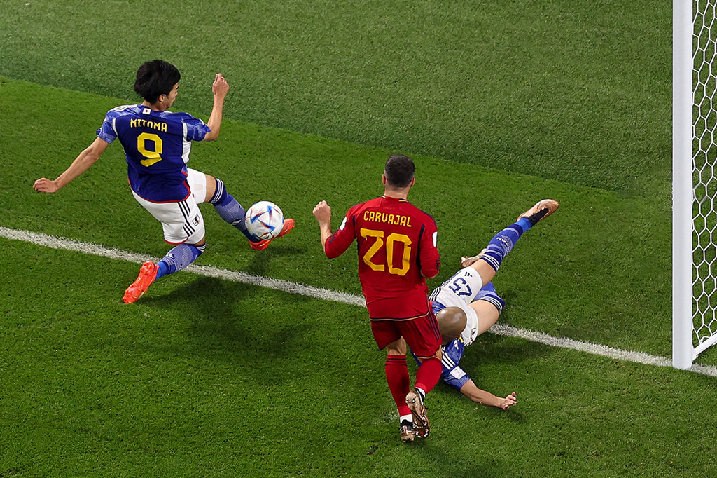 Foto do momento em que a bola parece ultrapassar a linha de fundo, logo antes do gol do Japão.