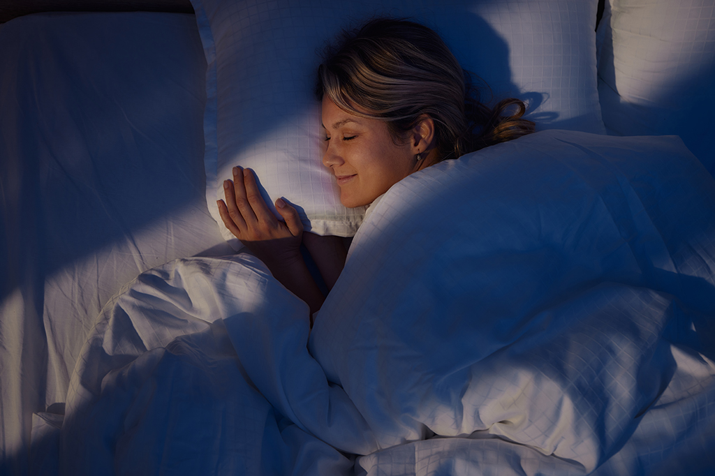 Mulher sorrindo enquanto dorme.