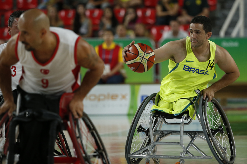 Jogadores paraolímpicos jogando basquete em cadeira de rodas.