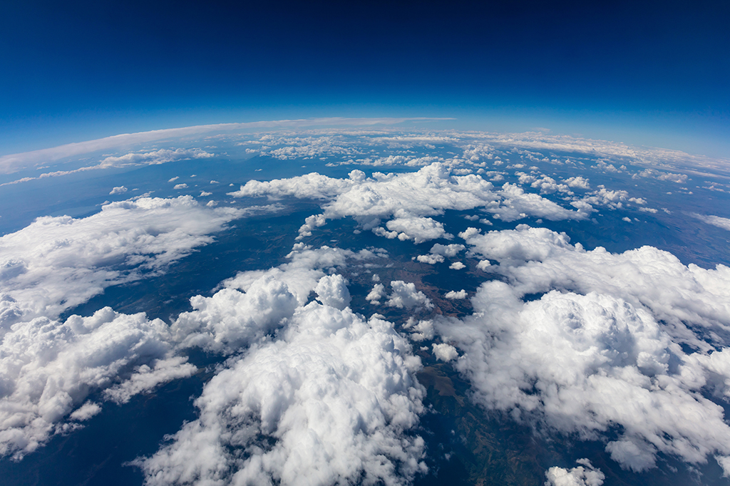 Foto da curvatura do planeta Terra. Tiro aéreo. Nuvens e céu azul.
