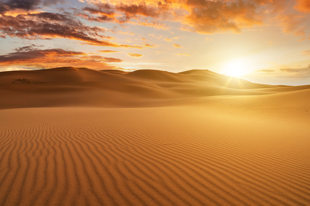 Imagem de pôr do sol no deserto.