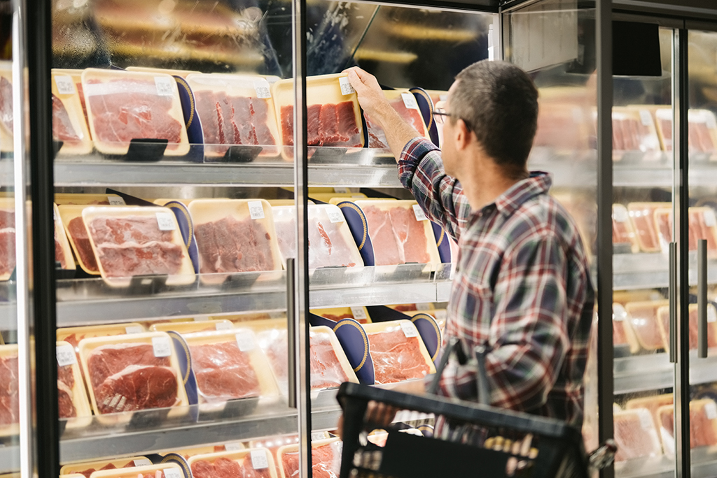 Foto de Homem que compra carne no supermercado.