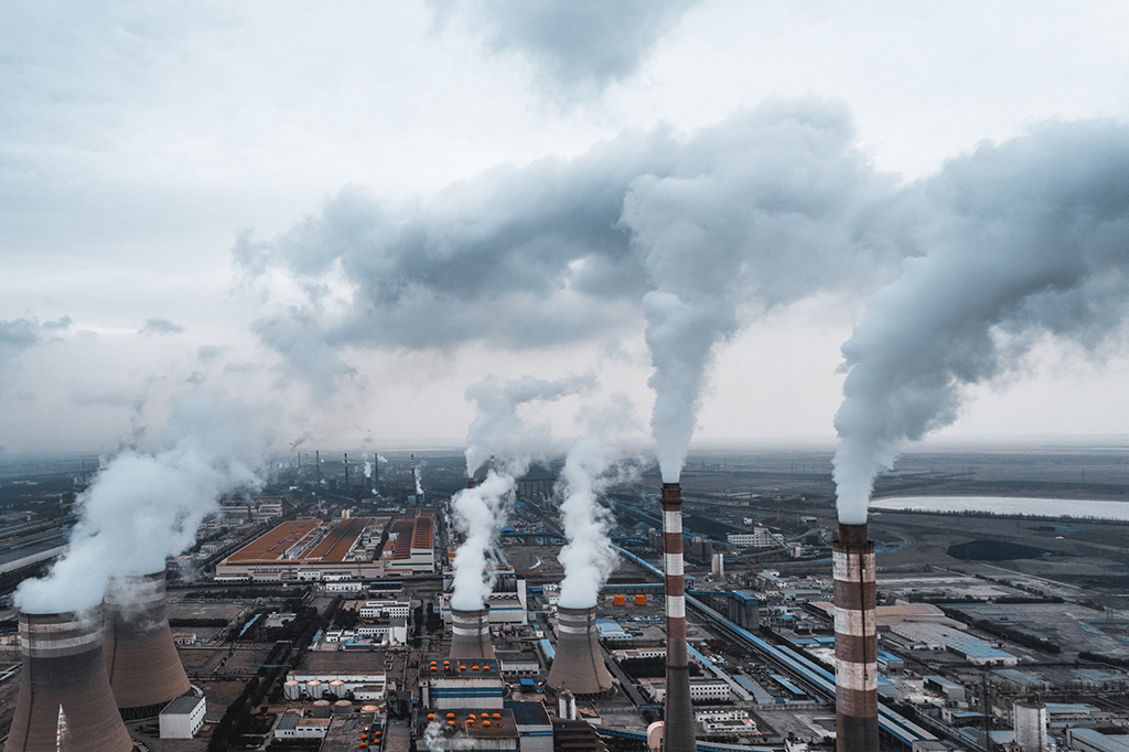 Fotografia de uma fábrica despejando CO2 no ar.