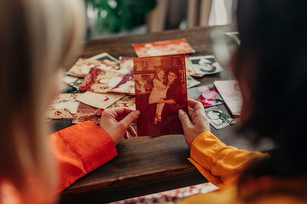 Fotografia de Mãe e filha olhando fotos de família.
