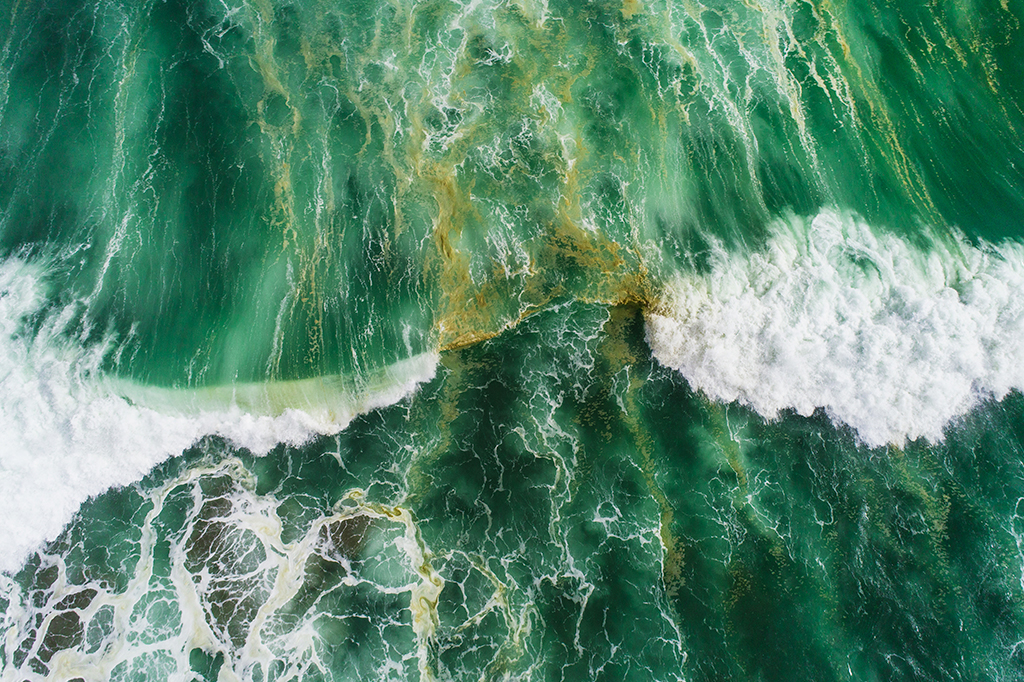 Fotografia da vista aérea de ondas espirrando no mar.